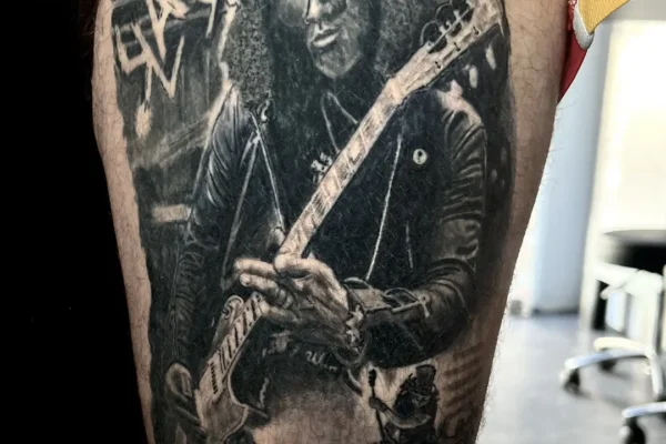 Tatuaje retrato de Slash (estilo superrealista) en el brazo