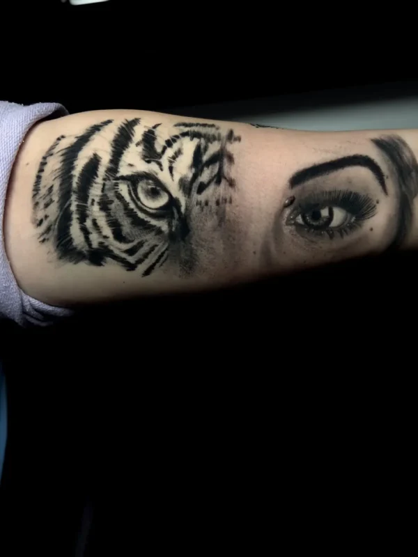 Tatuaje realista de mitad mujer, mitad tigre en el antebrazo