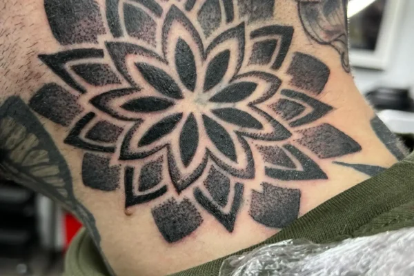 Tatuaje en el cuello lateral de mandala floral estilo blackwork ornamental hecho en Málaga