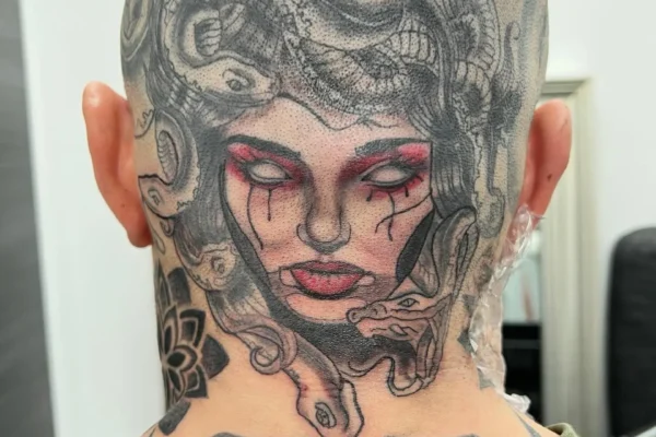 Tatuaje en la nuca de Medusa estilo realista con serpientes hecho en Málaga
